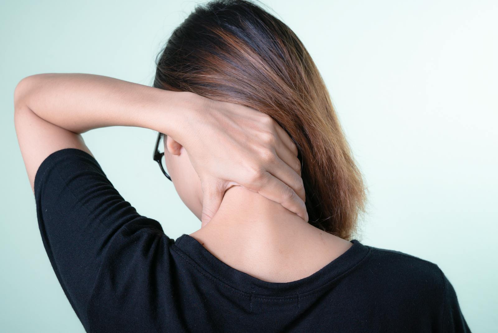 Woman massaging her neck at a desk