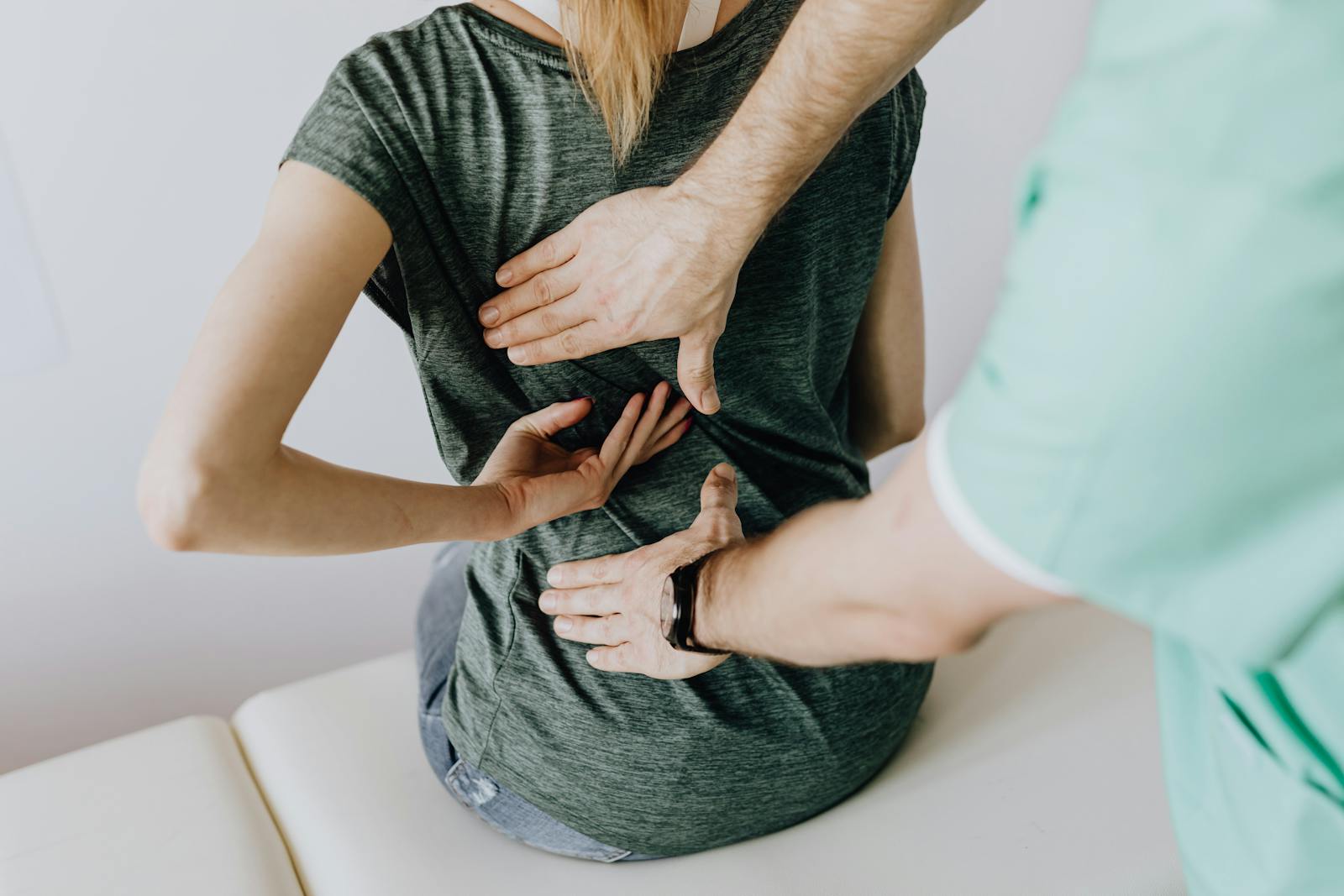 Clinician examining a patient's lower back