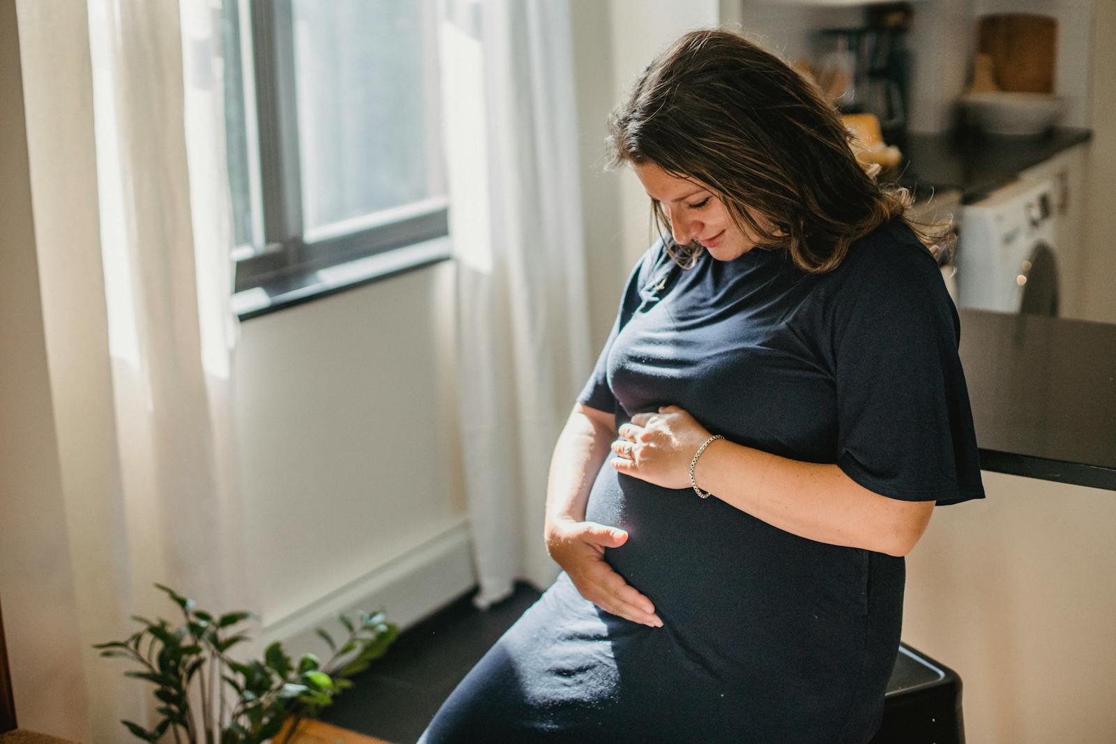 Expectant mother smiling and touching her belly