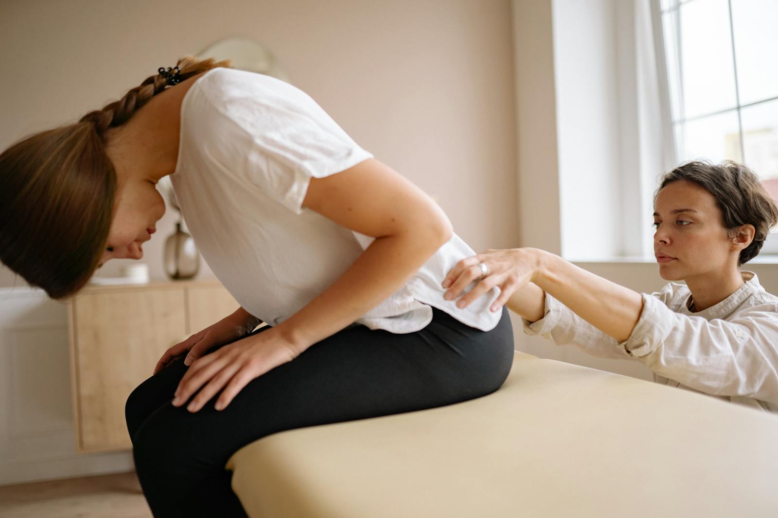 Therapist helping stretch a patient's back