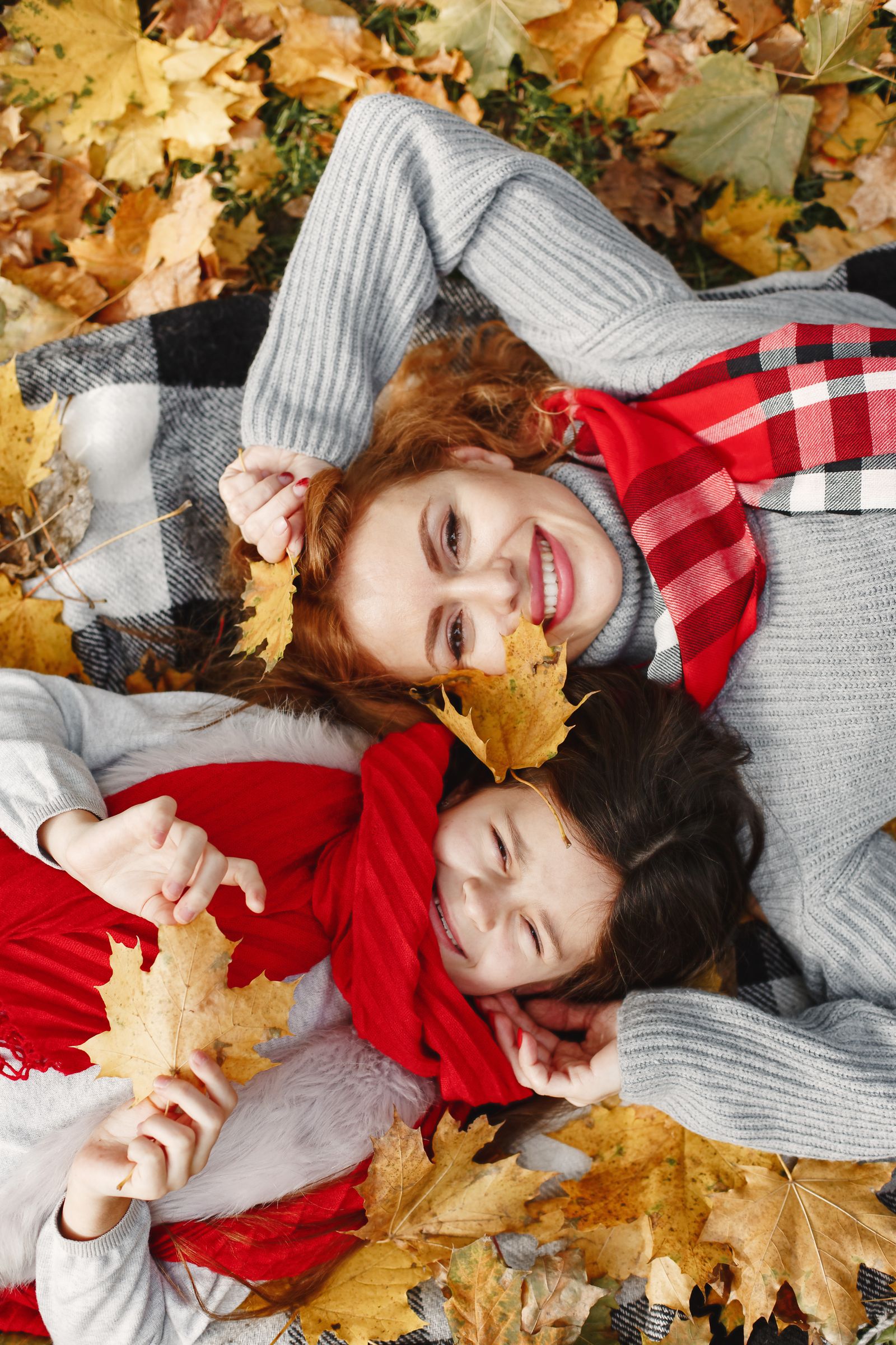 Mother and child among autumn leaves