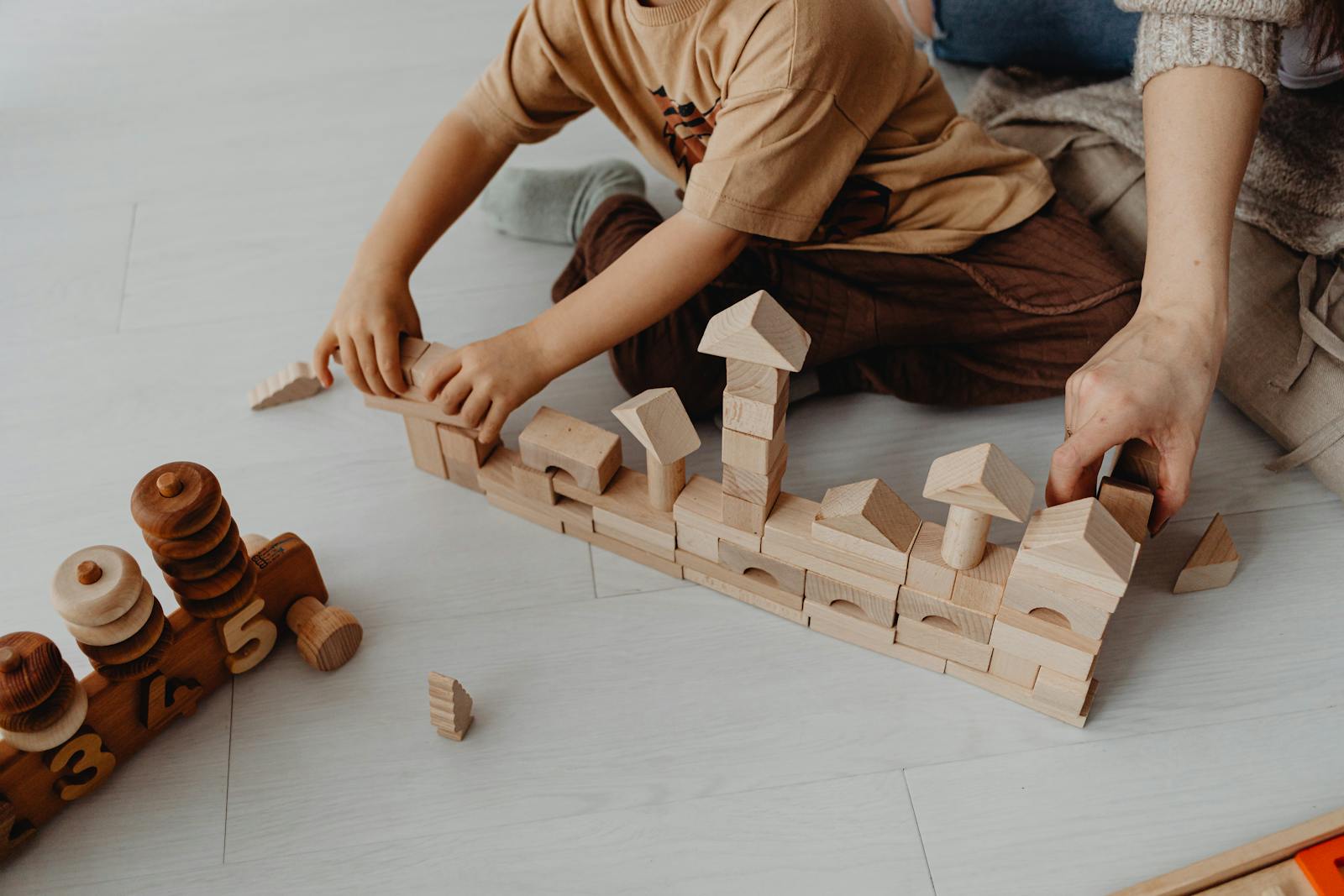 Adult and child building with wooden blocks together