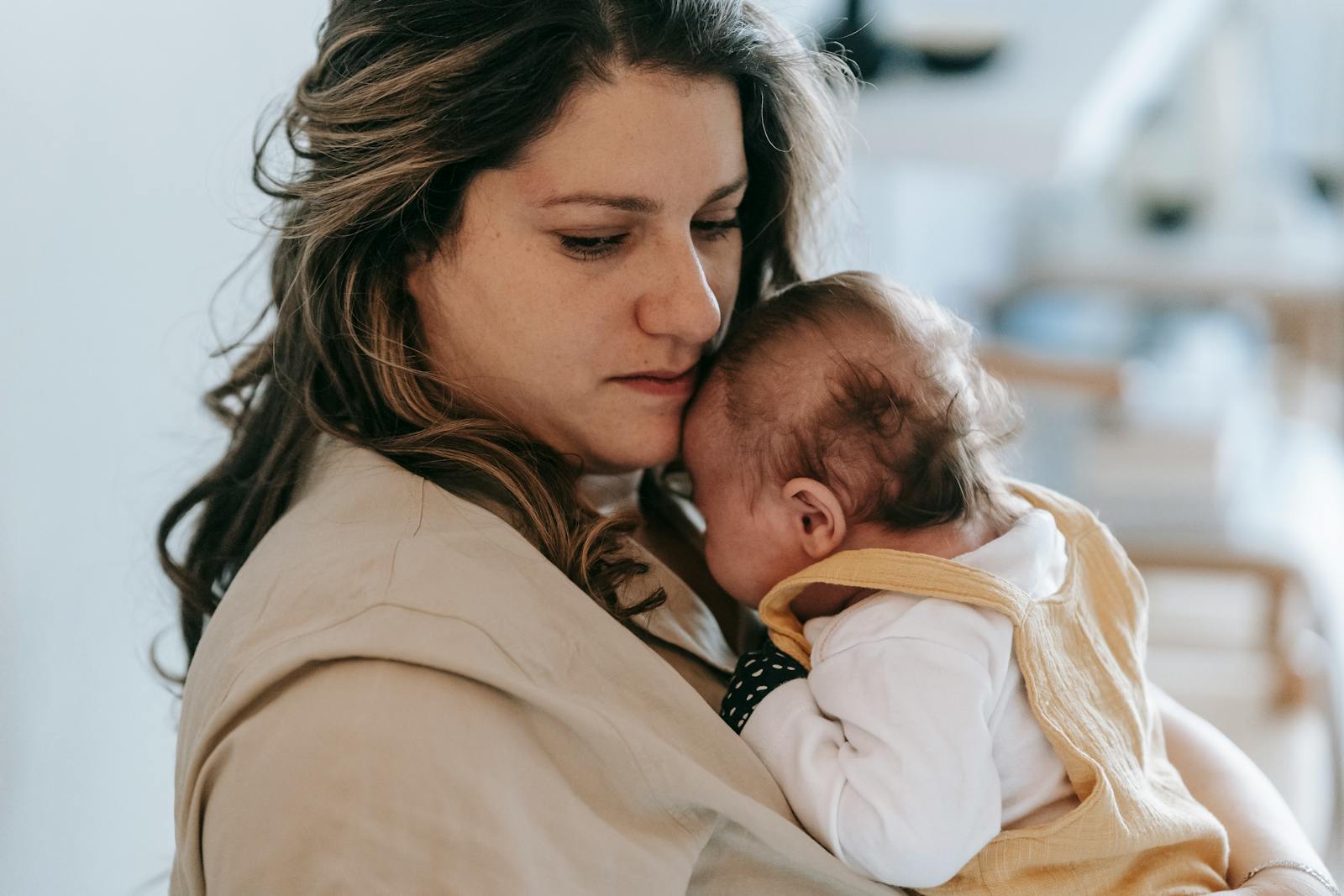 Mother gently holding her baby in a cozy home setting