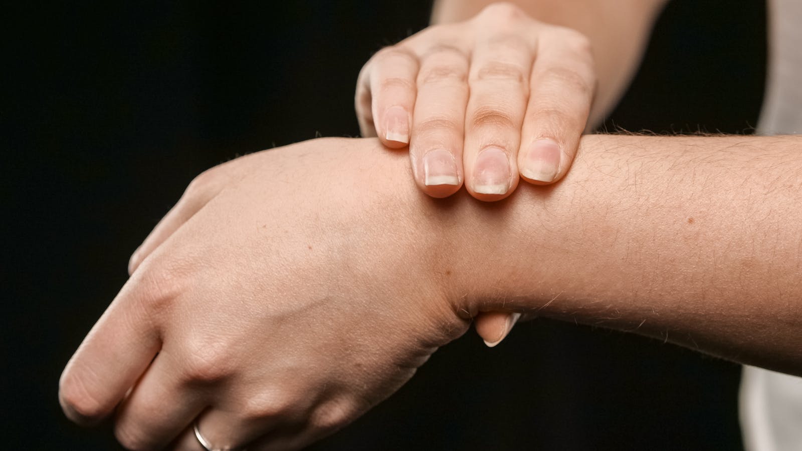 Close-up of hands pressing a sore wrist